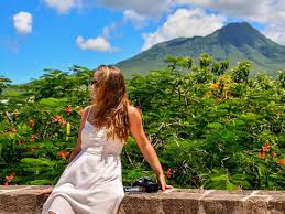 House-Sitting For Free, shows a young lady enjoying a tropical paradise mountain and tropical forest in the background!
